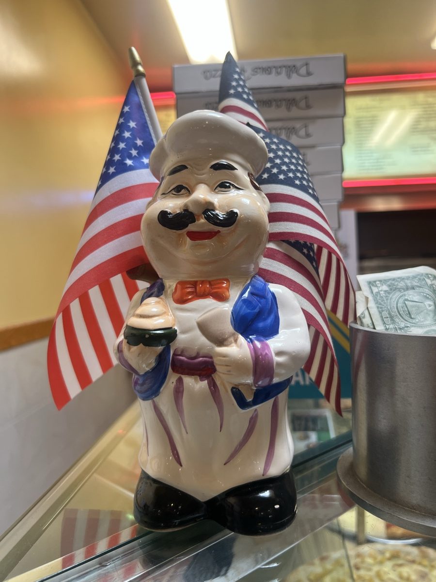 A ceramic chef figurine on the counter with American flags behind it