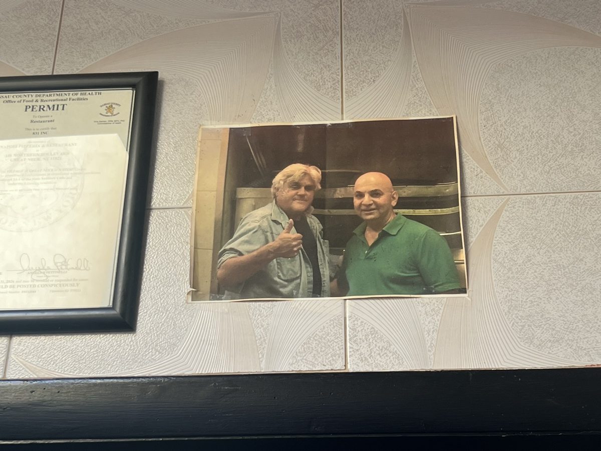 A photograph of two men displayed on the tiled wall at Napoli Pizza