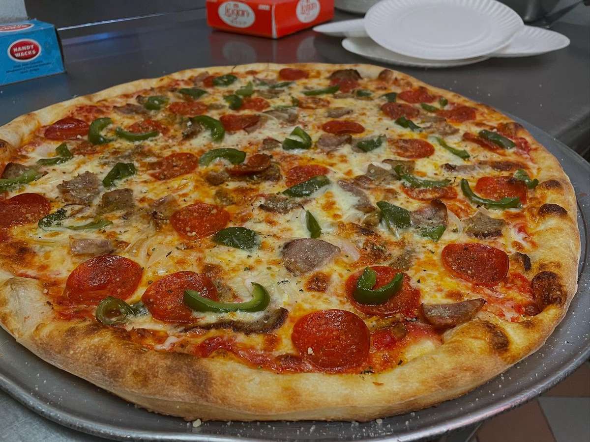 A pizza loaded with pepperoni, sausage and fresh peppers