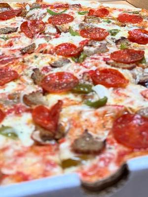 A full pepperoni and sausage pie in the box